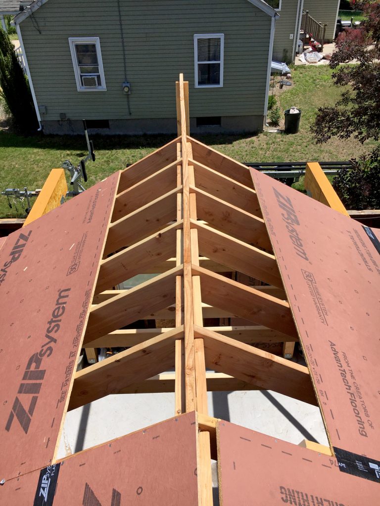 The rafters over the garage getting sheathed with zip board